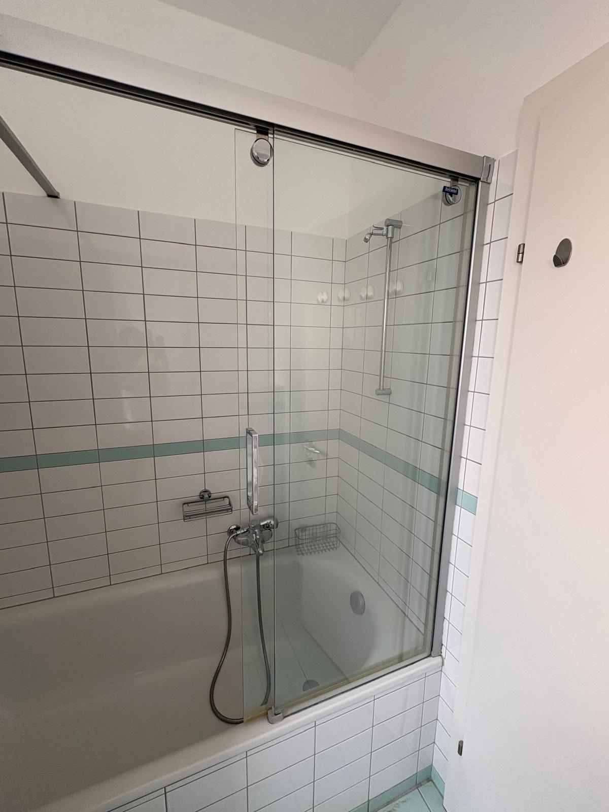 Bathroom with bathtub and glass shower screen