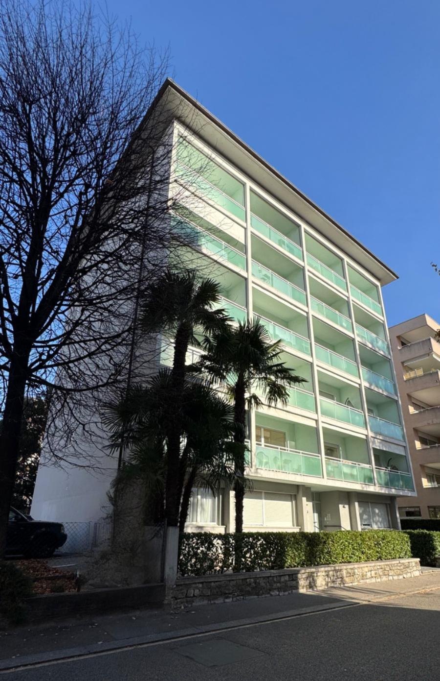Full facade of Via Tiglio 17 with palm trees in front