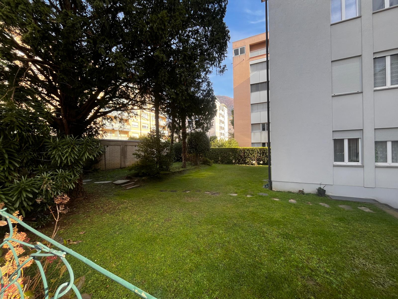 Rear garden of Via Tiglio 17 with tall trees and lawn