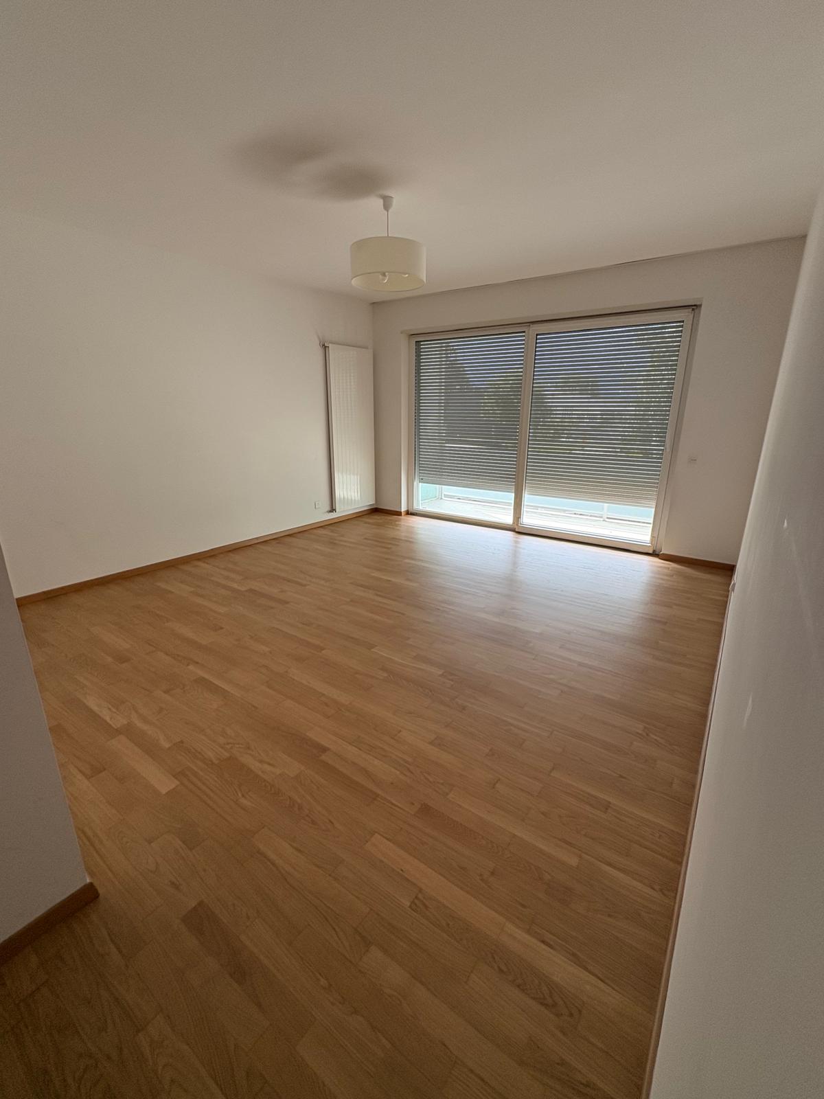 Empty living room with parquet floor and large sliding door